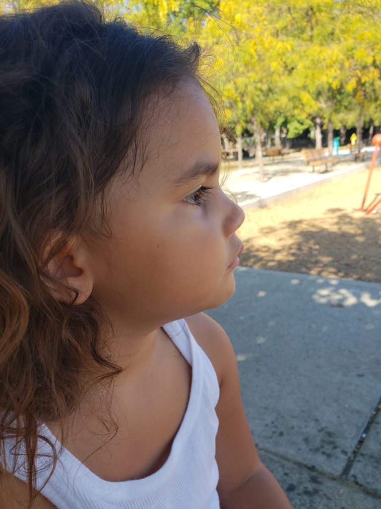 Ana Lia at 3 years old looking sweaty with park features in the background