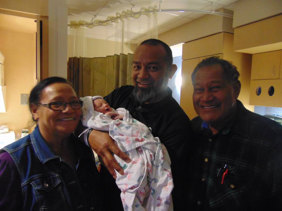 three adults with a newborn
