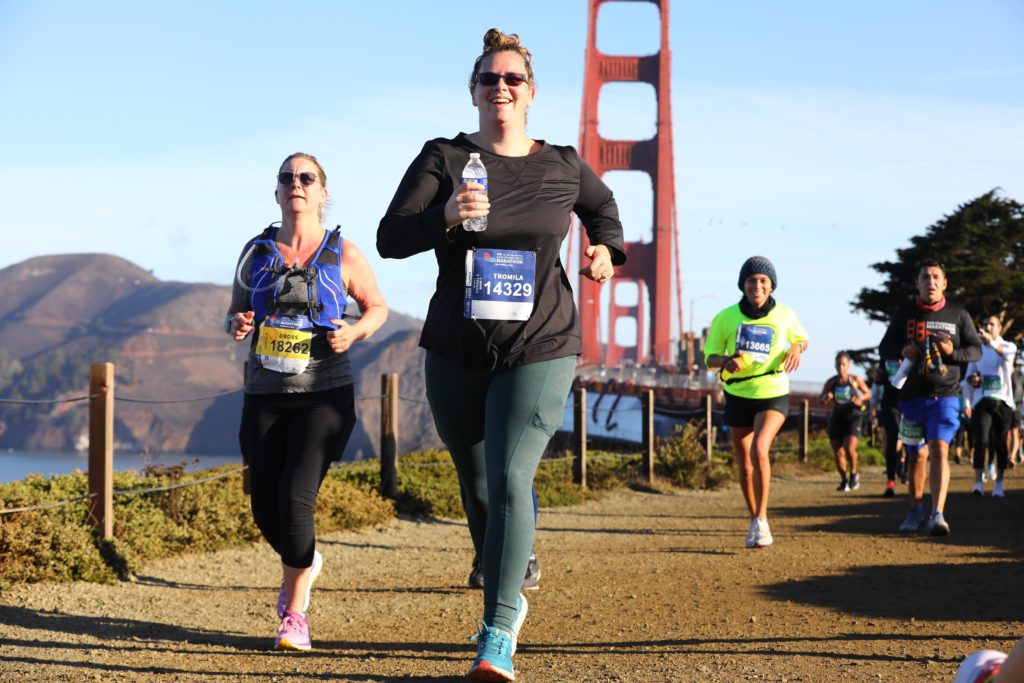 3 women running in front of golden gate bridge