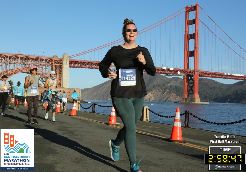 woman racing in front of golden gate bridge