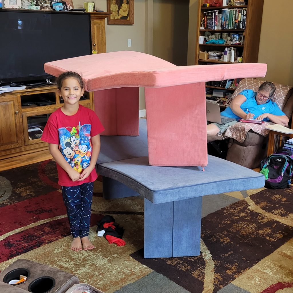 girl beside homemade fort