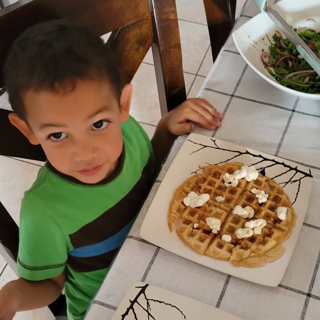 little boy eating waffle