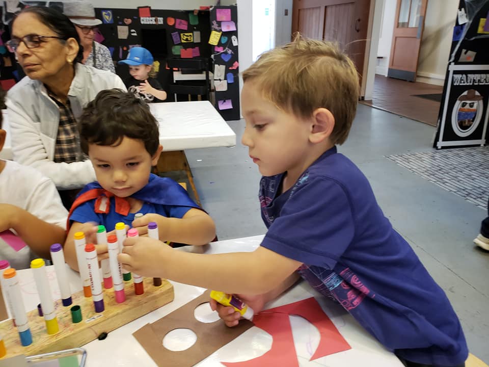 two boys drawing with markers