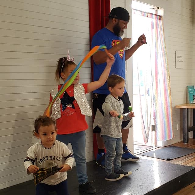 dad and three kids dancing