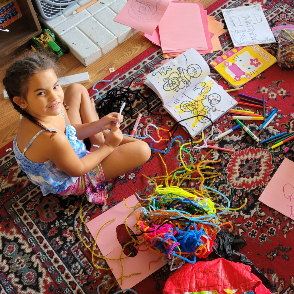 girl surrounded by craft materials