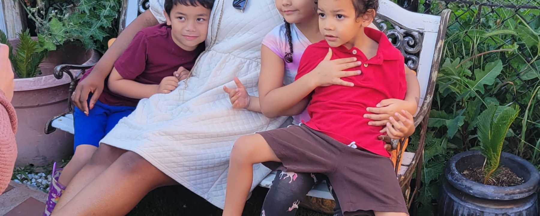 adult sitting with 3 kids