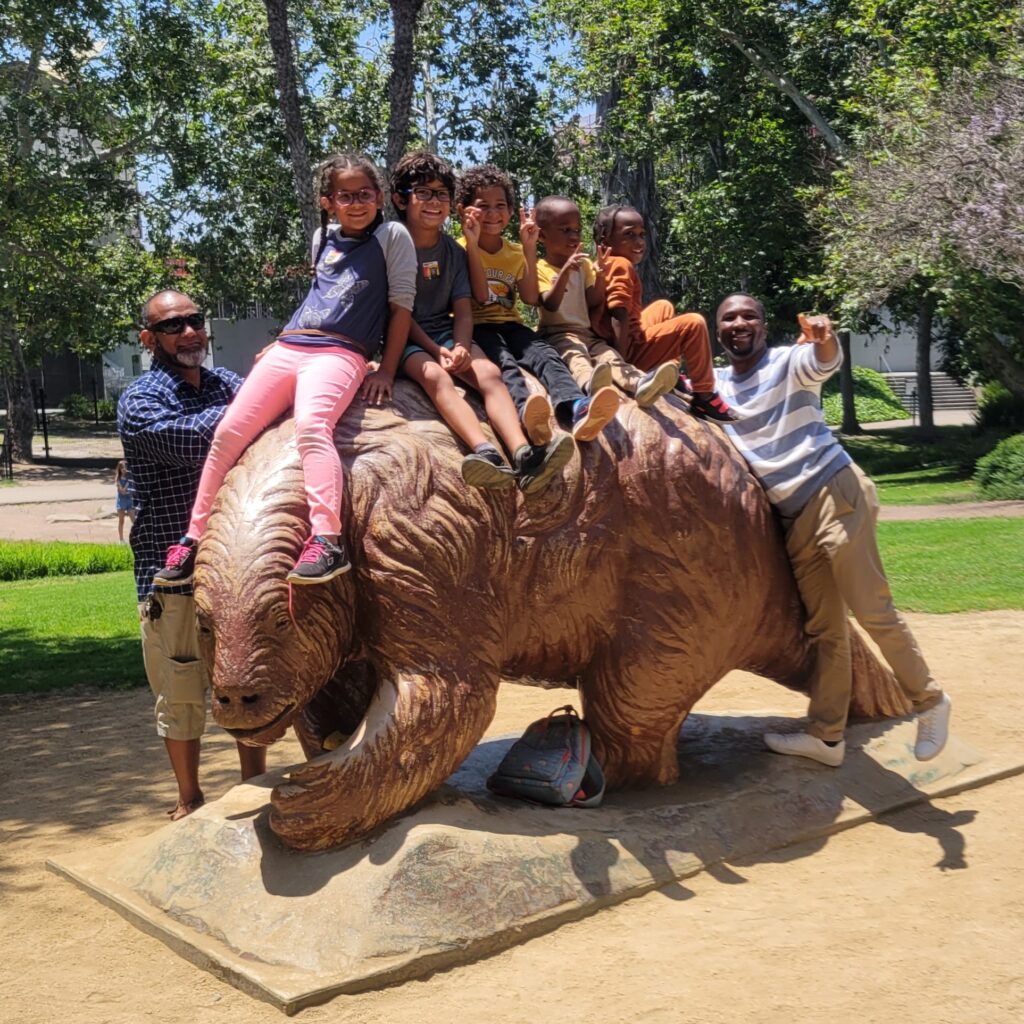 five kids and two dads on statue