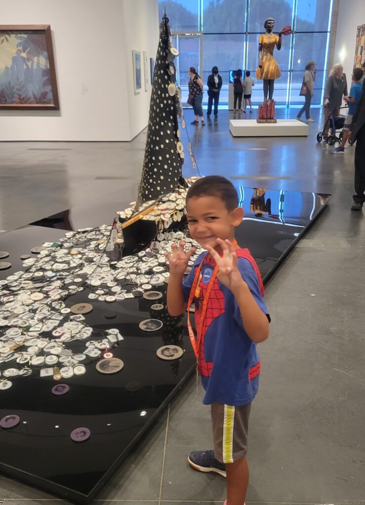 boy standing in front of art