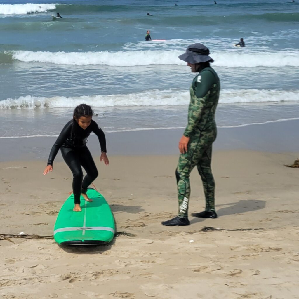girl on surf board with instructor