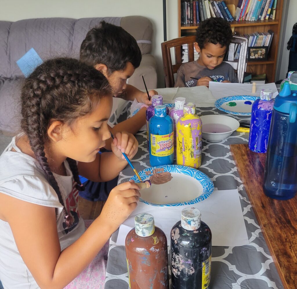 three kids painting at the table