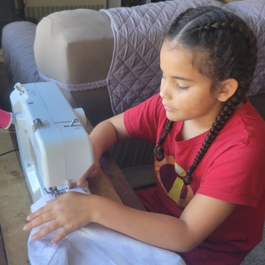 young girl sewing